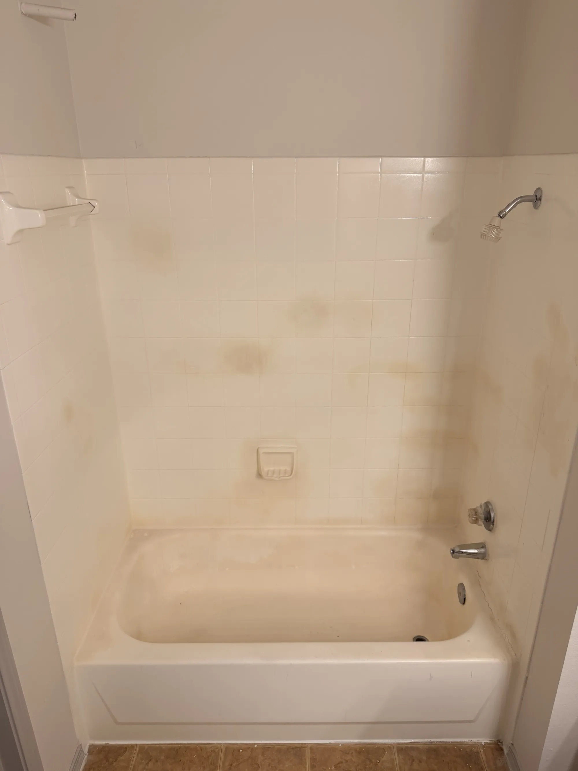 Tub-and-shower combo with yellowed, stained wall tile before refinishing