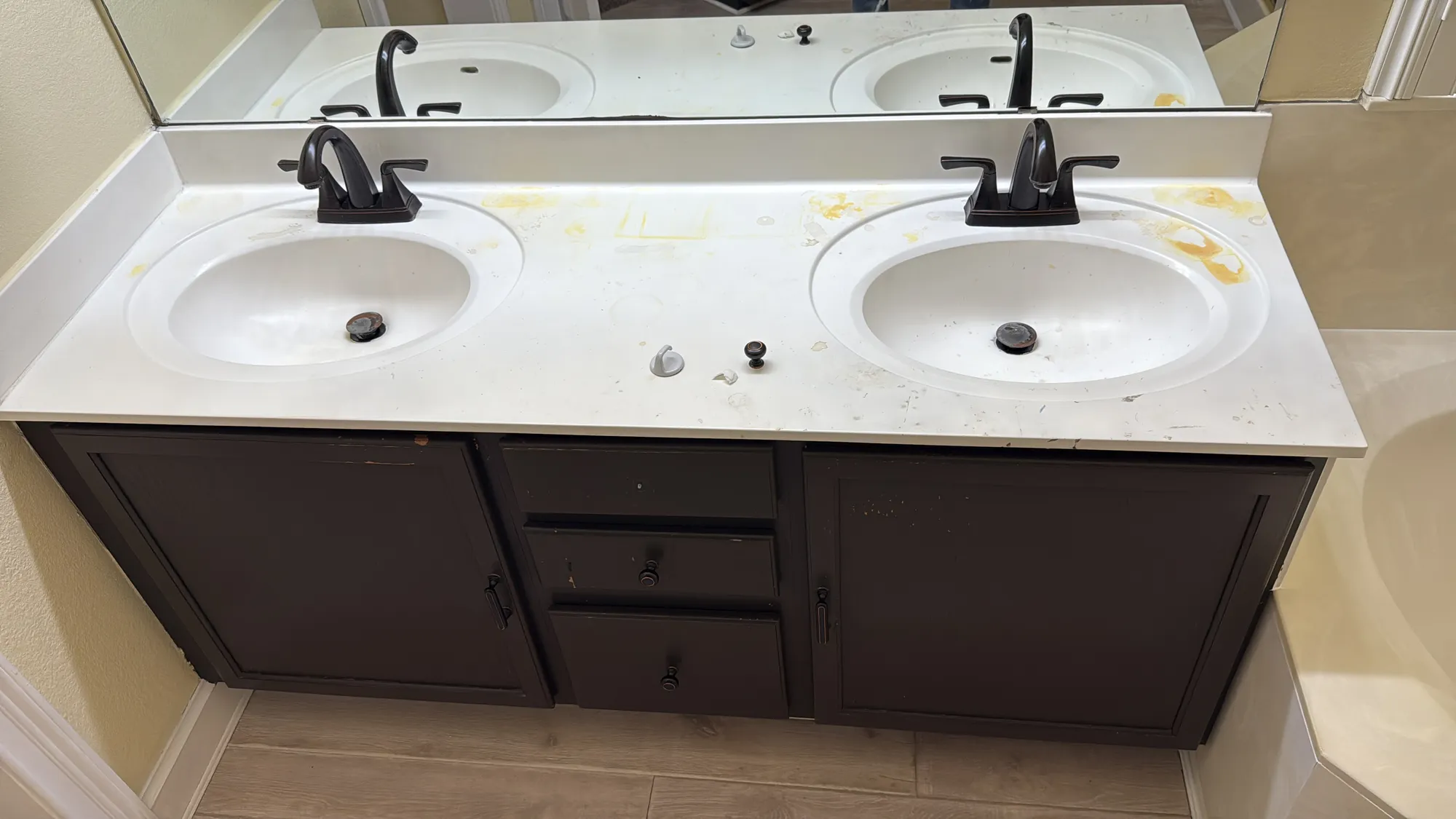 Bathroom vanity with dark espresso cabinets and a stained countertop before refinishing