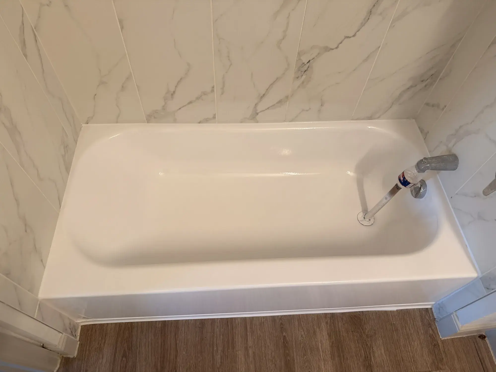 Bañera blanca reesmaltada con azulejo tipo mármol